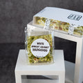 A packaged food product labeled 'WHITE APRICOT COCONUT HEDGEHOG' by Yeh Not Bad, shown in a clear bag with a round white label, alongside a white branded box on white display risers against a dark gray background.